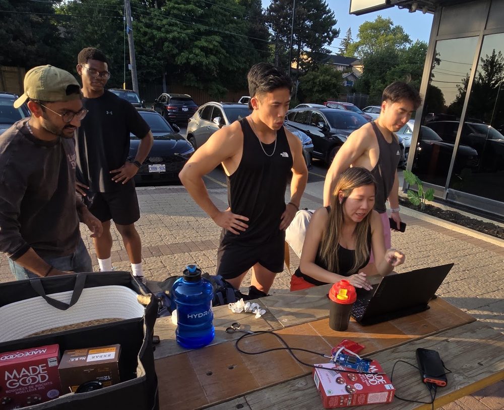 The team crowded around a laptop on a picnic table outside, reviewing step data during the 32g testing round